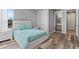 Bedroom featuring a modern bed with turquoise bedding, minimalist nightstands, and entryways to adjacent spaces at 4789 Terrace Bluff St, Winter Garden, FL 34787