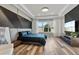 Well-lit bedroom featuring an accent wall, a large window, and a stylish entertainment center at 4789 Terrace Bluff St, Winter Garden, FL 34787