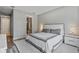 Neutral bedroom features a sleek bed with gray accents, minimalist nightstands, and a view into an ensuite bathroom at 4789 Terrace Bluff St, Winter Garden, FL 34787