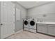 Functional laundry room with washer, dryer, sink, and storage cabinets at 4789 Terrace Bluff St, Winter Garden, FL 34787