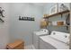 Functional laundry room with washer, dryer, shelving, decorative accents, and wall-mounted laundry sign at 4816 Cliveden Loop, Sanford, FL 32773