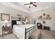 Comfortable bedroom features a tray ceiling, ceiling fan, and a decorative collection of hats on the wall at 4816 Cliveden Loop, Sanford, FL 32773