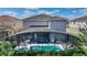 Aerial view of a home with a screened-in pool, showcasing the backyard layout and neighborhood at 5234 Wildwood Way, Davenport, FL 33837