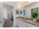 Bright bathroom featuring a granite countertop with double sinks, large mirror, and stylish décor at 5234 Wildwood Way, Davenport, FL 33837