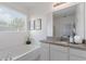 Bright bathroom featuring a granite countertop vanity, large mirror, and a relaxing soaking tub at 5234 Wildwood Way, Davenport, FL 33837