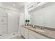 Bathroom showcasing a double sink with granite counters, a shower, and ample lighting at 5234 Wildwood Way, Davenport, FL 33837