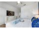 Bright bedroom featuring a dresser with television and a bed with white linens and blue decorative pillows at 5234 Wildwood Way, Davenport, FL 33837