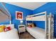 Bright bedroom featuring bunk beds, twin bed, playful decor, and vibrant blue walls at 5234 Wildwood Way, Davenport, FL 33837