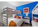 bedroom with bunk beds, blue accent wall and Mickey Mouse decor at 5234 Wildwood Way, Davenport, FL 33837