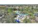 Aerial view of community pool with blue umbrellas, lounge chairs, palm trees, and water slide at 5234 Wildwood Way, Davenport, FL 33837