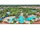 Aerial view of community pool area with multiple pools, a waterslide, lounge chairs and lush landscaping at 5234 Wildwood Way, Davenport, FL 33837