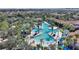 Stunning aerial view of a community pool area with lush landscaping, a splash pad, and many lounge chairs at 5234 Wildwood Way, Davenport, FL 33837