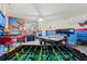 Spacious game room with a pool table, foosball table, and themed decor for entertainment at 5234 Wildwood Way, Davenport, FL 33837