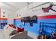 Comfortable seating area in a game room with Marvel-themed decor and a large TV at 5234 Wildwood Way, Davenport, FL 33837