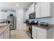 Bright kitchen featuring white cabinetry, stainless steel appliances, granite counters, and ample counter space at 5234 Wildwood Way, Davenport, FL 33837