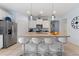 Modern kitchen island featuring granite countertops, stainless steel appliances, and stylish bar stool seating at 5234 Wildwood Way, Davenport, FL 33837