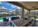 Outdoor dining on the screened patio features a ceiling fan and a view of the pool at 5234 Wildwood Way, Davenport, FL 33837