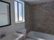 Updated bathroom features new tiling, vanity, mirror, fixtures, and bright natural light from the window at 5415 Fairwood Way # 303, Orlando, FL 32808