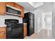 Kitchen with wood cabinets, black appliances and white counter tops at 5415 Fairwood Way # 303, Orlando, FL 32808