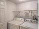 Dedicated laundry area with washer, dryer, and built-in storage shelving at 5415 Fairwood Way # 303, Orlando, FL 32808