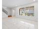 Spacious living area with large windows, white tile floor, and stairs to the upper level at 5415 Fairwood Way # 303, Orlando, FL 32808