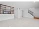 Open living room with tile floors, a staircase and a framed view into the kitchen area at 5415 Fairwood Way # 303, Orlando, FL 32808