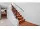 Staircase leads up to the second floor of the home and features wood steps and a black metal railing at 5415 Fairwood Way # 303, Orlando, FL 32808
