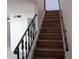 Wooden staircase with decorative metal railing leading to the upper level at 5415 Fairwood Way # 303, Orlando, FL 32808