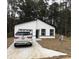 Charming single-story home featuring a white exterior, black trim, and a concrete driveway at 6937 Se 23 Ave, Ocala, FL 34480