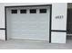 Close up view of garage door with 6937 address plate, white door, and black trim at 6937 Se 23 Ave, Ocala, FL 34480