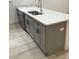 Kitchen island featuring gray cabinets, stainless steel sink and quartz countertop at 6937 Se 23 Ave, Ocala, FL 34480