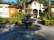 Outdoor water feature with a three-tiered fountain surrounded by trimmed hedges and a brick walkway at 713 Crest Pines Dr # 227, Orlando, FL 32828