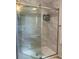 Modern shower with glass doors, tiled walls, and convenient shelving at 723 Polo Park East Blvd, Davenport, FL 33897