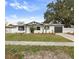 Charming single-story home with white facade, black trim, attached garage, and well-maintained front lawn at 7331 Blue Jacket W Pl, Winter Park, FL 32792