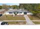 Aerial view of charming home featuring a well-maintained lawn, dark garage door, and welcoming curb appeal at 7331 Blue Jacket W Pl, Winter Park, FL 32792