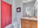 Bright bathroom featuring a shower with red curtain and a vanity with wood cabinets at 8452 Crystal Cove Loop, Kissimmee, FL 34747