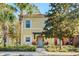 Charming yellow two-story townhouse featuring a well-maintained front yard with lush greenery and palm trees at 8452 Crystal Cove Loop, Kissimmee, FL 34747