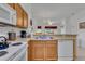 Kitchen features modern white appliances, a stainless-steel sink, and light wood cabinets at 8452 Crystal Cove Loop, Kissimmee, FL 34747