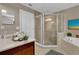 Bright bathroom featuring a glass shower, soaking tub, and elegant vanity with white orchids at 864 Stonechase Ln, Lake Mary, FL 32746