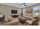 Inviting living room with plush seating, large windows, and a ceiling fan, creating a relaxing space at 864 Stonechase Ln, Lake Mary, FL 32746