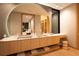 Modern bathroom featuring double sinks, a large round mirror, and sleek cabinetry at 8966 Easterling Dr, Orlando, FL 32819