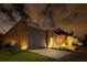 Contemporary home exterior at night, featuring wood and metal siding, with landscape lighting at 8966 Easterling Dr, Orlando, FL 32819