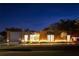 Modern home exterior at night with striking wood and concrete accents and landscape lighting at 8966 Easterling Dr, Orlando, FL 32819