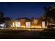 Modern home exterior showcasing wooden accents, multiple windows, and professional landscaping at night at 8966 Easterling Dr, Orlando, FL 32819