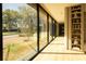 Light-filled hallway with floor-to-ceiling windows, hardwood floors and built-in shelving offers views of the pool and backyard at 8966 Easterling Dr, Orlando, FL 32819