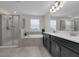 Bright bathroom with dual sink vanity, soaking tub, and glass-enclosed shower at 8995 Croquet Ct, Champions Gate, FL 33896