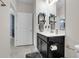 Modern bathroom featuring a dark vanity with white countertop and storage shelves at 8995 Croquet Ct, Champions Gate, FL 33896