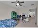 Bedroom with neutral walls and carpet, a ceiling fan, and an adjacent office area at 8995 Croquet Ct, Champions Gate, FL 33896