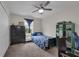 Cozy bedroom features carpet, ceiling fan, and a vibrant blue floral patterned bedspread at 8995 Croquet Ct, Champions Gate, FL 33896