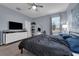 Bedroom with ceiling fan, large window, and a television on a modern dresser at 8995 Croquet Ct, Champions Gate, FL 33896